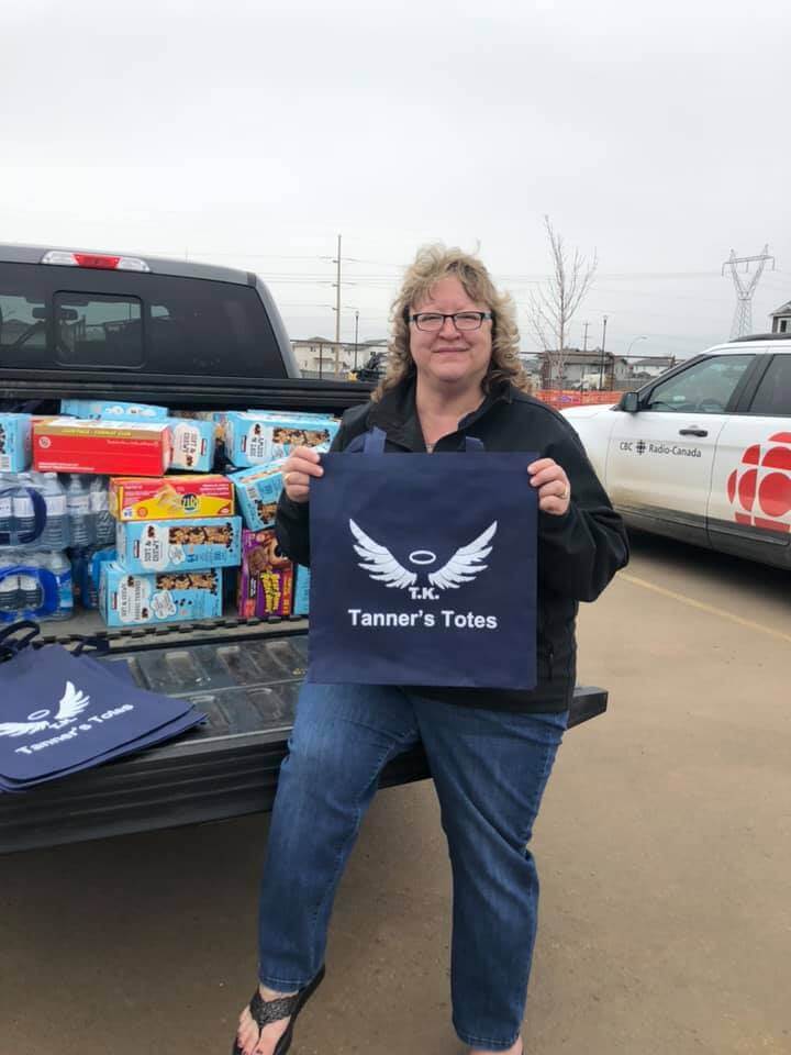 Kim Krupa holding a tote with a truckload of donated supplies